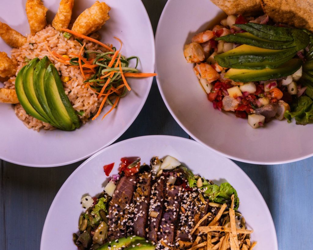Three flavorful dishes featuring seafood and avocado, plated creatively for a delightful meal.