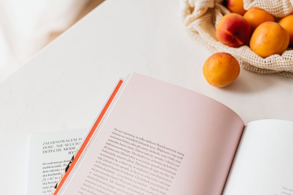 pexels photo 4397904 4397904 From above of opened book placed on white table near cotton sack with natural ripe apricots