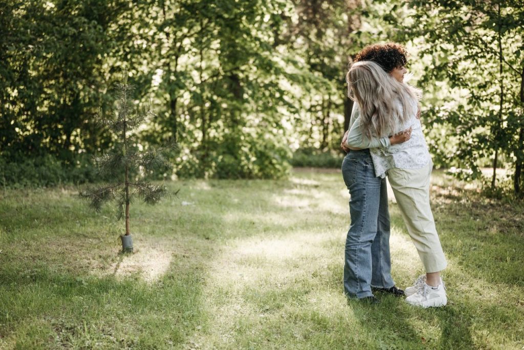 Newsletter A loving couple embraces in a serene forest glade, surrounded by lush greenery.